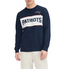 Upgrade your New England Patriots look with this Peter T-shirt. This Tommy Hilfiger tee features bold graphics and a classic design with a team wordmark across the chest. This soft cotton tee is a casual yet stylish choice for game day. Screen print graphics Brand: Tommy Hilfiger Imported Flatlock stitching Officially licensed Machine wash, tumble dry low Long sleeve Material: 100% Cotton Embroidered fabric applique Woven tag Long Sleeve Sports T-shirt With Team Logo, Fan Apparel Long Sleeve Relaxed Fit T-shirt, Collegiate Long Sleeve T-shirt With Relaxed Fit, Long Sleeve T-shirt With Team Name For Fans, Navy Cotton T-shirt For Sports Season, Collegiate Long Sleeve Tops With Team Logo, Sports Fan Long Sleeve Top With Team Logo, Long Sleeve T-shirt With Team Logo For Fan Gear, Long Sleeve Cotton T-shirt With Team Name