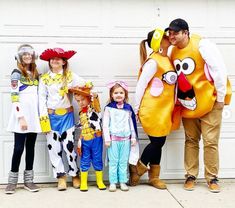 a group of people standing next to each other near a garage door and wearing costumes