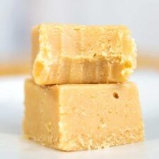 two pieces of yellow fudge sitting on top of each other in front of a white plate