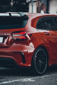 the rear end of a red car parked in a parking lot