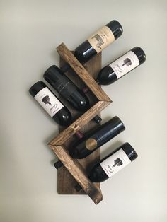 several bottles of wine are placed in a wooden holder