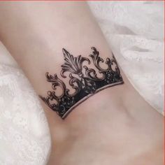 a black crown tattoo on the ankle