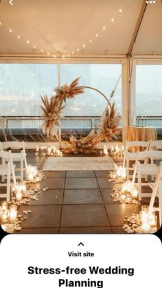 an indoor wedding setup with candles and flowers on the floor in front of large windows