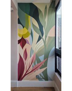 a painting on the wall in a room with wood flooring and walls painted with different colors