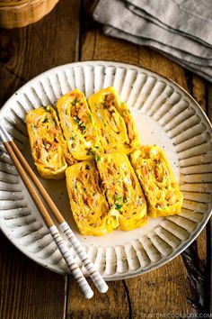 an egg dish on a plate with chopsticks