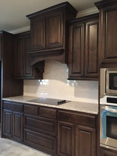 a kitchen with brown cabinets and white counter tops