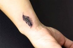 a small feather tattoo on the wrist