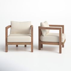 two wooden chairs sitting next to each other on a white surface with one chair facing the other