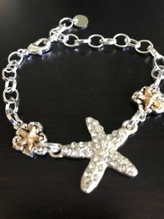 Bling starfish bracelet. Silver stone rhinestone starfish flanked on each side by a smaller gold tone starfish bead. Aluminum chain with round, flat finishing bead. I may change my favorite color or stone or style, but the ocean is always involved. light and fun to wear! Adjustable from 6 to 9 inches. Starfish Bracelet, My Favorite Color, Bracelet Silver, Starfish, The Ocean, Favorite Color, Jewelry Bracelets, Gold Tones, My Favorite