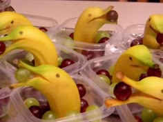 plastic containers filled with grapes and bananas as if they're eating fruit from the same container