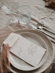 a place setting with napkins, wine glasses and silverware