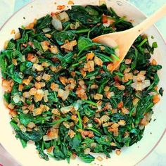 a white bowl filled with spinach and onions