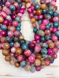 multicolored marble beads are arranged on a white surface, with one bead in the middle