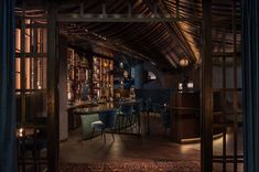 a dimly lit bar with blue chairs and bookshelves