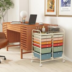 a computer desk with many drawers and a laptop on it's stand next to a chair