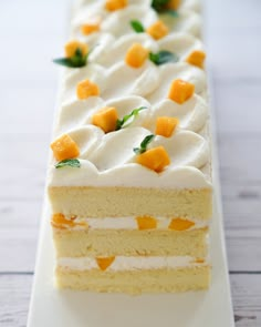 a piece of cake with white frosting and orange pieces on it sitting on a plate