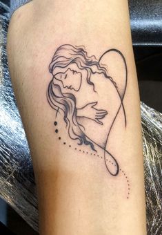 a woman's arm with a tattoo on it that has a heart in the middle