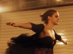 a woman in a black dress is dancing