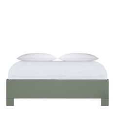 a bed with two pillows on top of it and one pillow is white, the other is green