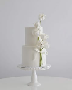 a white wedding cake with flowers on top