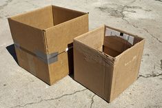 two cardboard boxes sitting on the ground next to each other