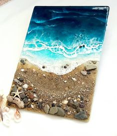 a glass tile with shells and starfish on the beach