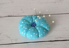 a blue pin cushion sitting on top of a wooden floor