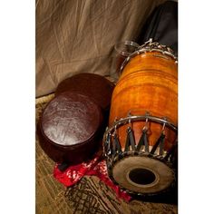 two musical instruments sitting on top of a carpet next to a bag and cloth covered wall