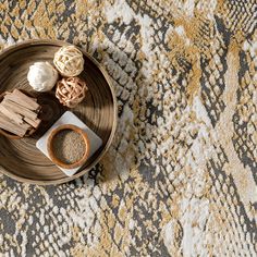 a wooden bowl filled with food on top of a table next to a white and yellow rug