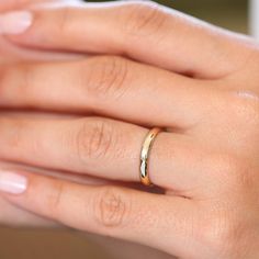 a woman's hand with a gold ring on it