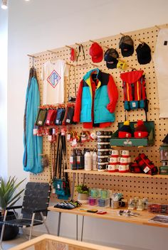 there are many items on the pegboard in this shop, including hats and jackets