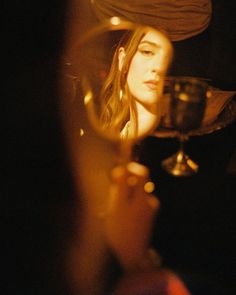 a woman holding a wine glass in front of her face