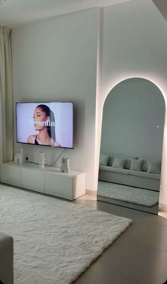 a flat screen tv mounted to the side of a wall next to a white couch