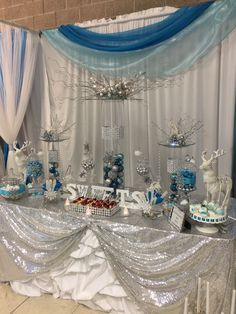 the dessert table is set up with blue and silver decorations