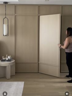 a woman is standing in front of a sliding door and looking into the living room