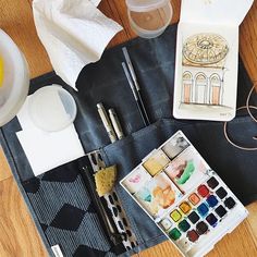 an artist's work bag with watercolors, brushes and other art supplies