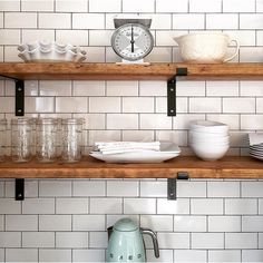 the shelves are filled with dishes and cups on top of each other in front of a clock