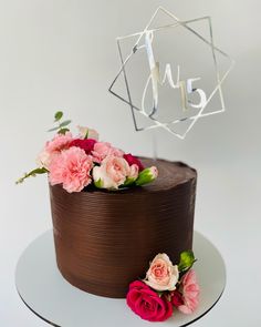 a chocolate cake with pink flowers on top and the word love spelled in white letters