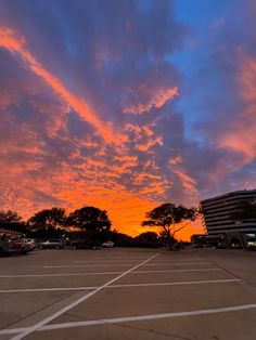 an empty parking lot under a colorful sky