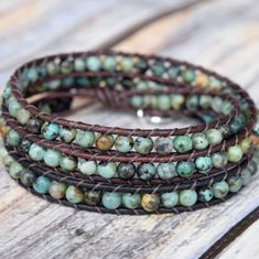 African Turquoise stones and genuine leather make up this gorgeous 3 layer wrap bracelet. Always a favorite of jewelry addicts and fashionistas alike. If you want color, start here first. Features our very popular "Tree of Life" button closure. A Bluefish Classic! 4mm (.157") diameter African Turquoise gemstones Silver finished "Tree of Life" button closure, 15mm (.59") diameter Ombre brown, designer leather Signature Bluefish logo heart charm 51 - 56 cm/20 - 22" length 3 button loop adjustments Wrap Bracelet Tutorial, Gemstone Wrap Bracelet, Turquoise Wrap Bracelet, Warm Browns, Multi Wrap Bracelet, Boho Wrap Bracelet, Ombre Brown, Beads Bracelet Design, African Turquoise