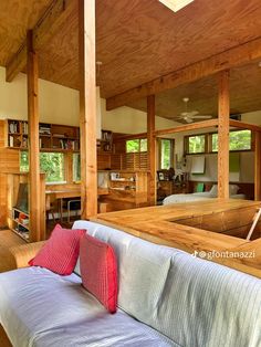 a living room filled with furniture and lots of wooden beams on the ceiling, along with bookshelves