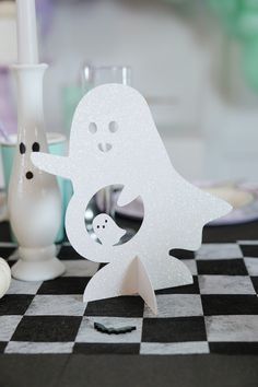 there is a white paper ghost with a baby in it's arms on the table