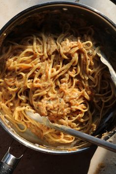 a pot filled with pasta and sauce on top of a table