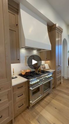 a kitchen with wooden cabinets and stainless steel stove top oven in the center of the room