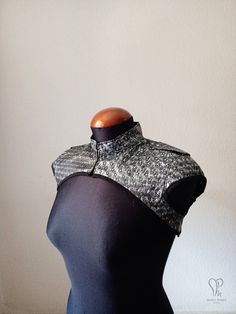 a mannequin wearing a black and white top with silver sequins on it