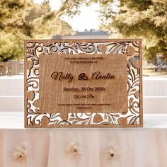 a wooden wedding card sitting on top of a table