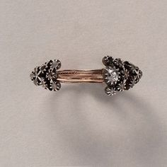 A gold and diamond flower puzzle ring consisting of 5 separate rings held together at the bottom, the rings move individually and are each holding a part of a bouquet of flowers. The bouquet itself is made out of silver and set with rose cut diamonds. The third and center ring holds the middle of the bouquet and is set with a larger old cut diamond, 19th century, Portuguese. Puzzle Rings, Flower Puzzles, Puzzle Ring, A Bouquet Of Flowers, Bouquet Of Flowers, Diamond Flower, Rose Cut Diamond