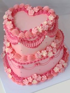 a heart shaped cake with pink icing and flowers