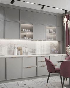 a kitchen with grey cabinets and pink chairs