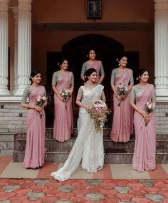 a group of women standing next to each other in front of a white building with columns